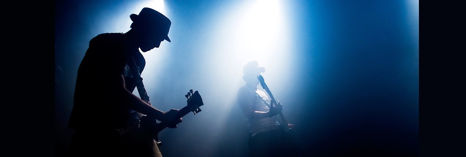 Guitarists silhouetted on stage